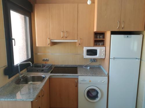 a kitchen with a sink and a white refrigerator at Apartamento rural en bronchales, Sierra de Albarracín in Bronchales
