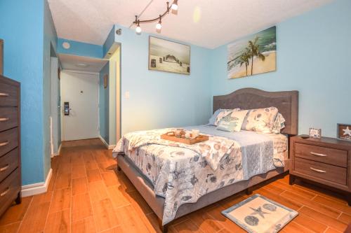 Daytona Condo with Beautiful Ocean and City View في دايتونا بيتش: غرفة نوم مع سرير مع خزانة وسرير sidx sidx sidx