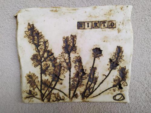 a plate with a painting of flowers on a wall at Agriturismo Le Piccole Macìe in Magliano in Toscana