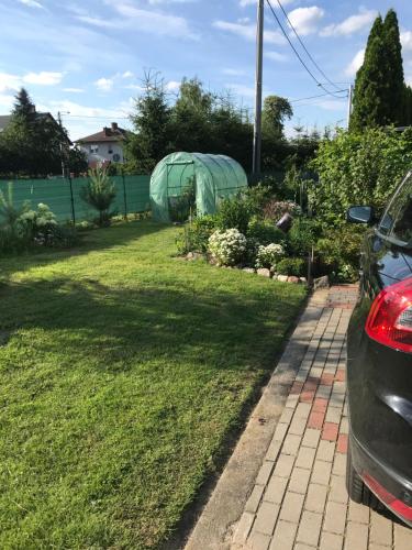 a yard with a green tent in the grass at Mazury Apartament in Ostróda