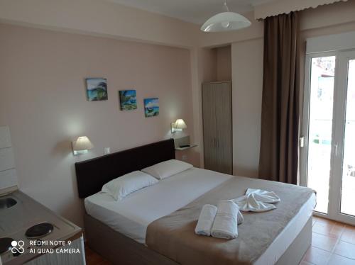 a bedroom with a bed with two towels on it at Teo Rooms in Paralia Katerinis