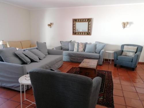 uma sala de estar com sofás e cadeiras e um espelho em Marchanta em Santarém