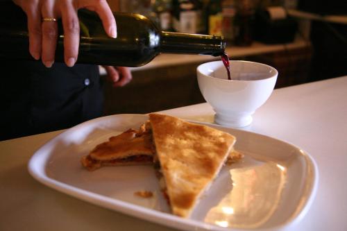 a person pouring a bottle of wine into a plate of food at As Chivas in Redondela