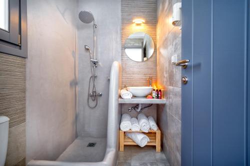 a bathroom with a shower and a sink and a tub at Ammos Serifos in Serifos Chora