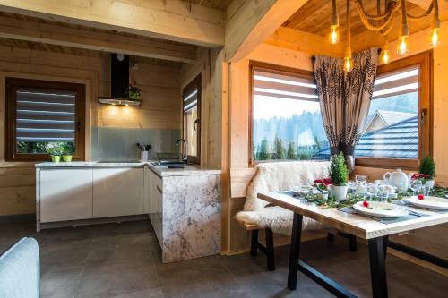 a kitchen and living room with a table and a kitchen and a dining room at Domek & Apartament Na Ogrodzie in Suche