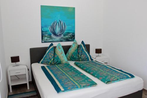 una camera da letto con un letto con cuscini blu e verdi di Haus Mup a Spittal an der Drau