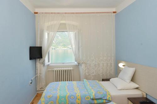 a small bedroom with a bed and a window at Pana-Eustahije 253 in Kotor