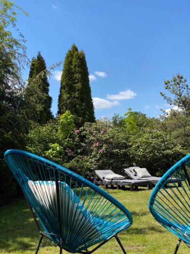 deux chaises bleues assises dans l'herbe dans une cour dans l'établissement Heidequartier, à Bispingen