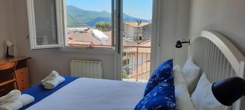 a bedroom with a bed and a large window at Mundaka Sea & Mountain Views. Wifi, Parking in Mundaka