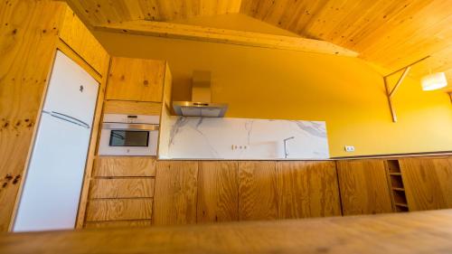 a kitchen with wooden cabinets and a white counter top at Eco-Apartaments Cal Rossa de Taús in Taús
