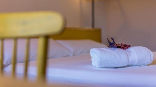 a white towel on a bed with a chair at Eco-Apartaments Cal Rossa de Taús in Taús
