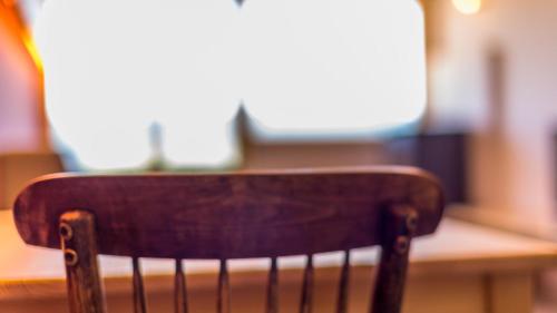 a wooden chair sitting in front of a table at Eco-Apartaments Cal Rossa de Taús in Taús