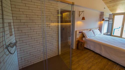 a bedroom with a glass shower and a bed at Eco-Apartaments Cal Rossa de Taús in Taús