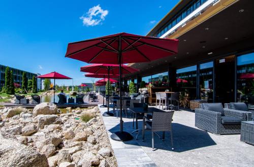 a patio with red umbrellas in front of a building at Meiser Design Hotel in Dinkelsbühl