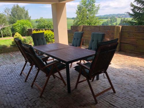 a wooden table and chairs on a patio at Chalupa U Ptáčků in Kamenice nad Lipou