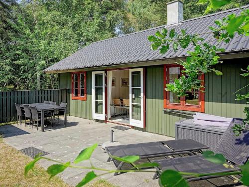 a green and red house with a table and chairs at 6 person holiday home in Nex in Snogebæk