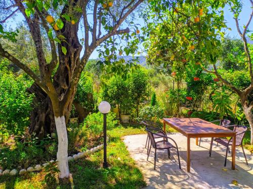 einen Tisch und Stühle neben einem Baum in der Unterkunft Harmony Garden in Parga
