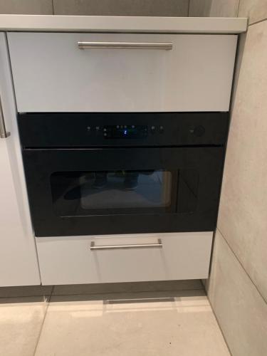 un horno blanco y negro en una cocina en Les oyats, en Nieuwpoort