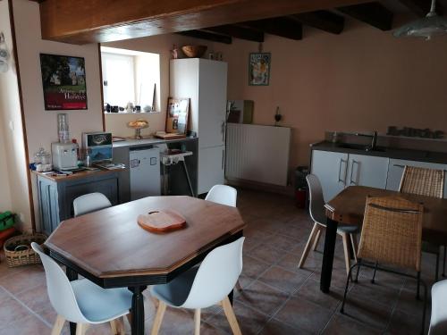 a kitchen and dining room with a wooden table and chairs at La Parisiere in Gavray