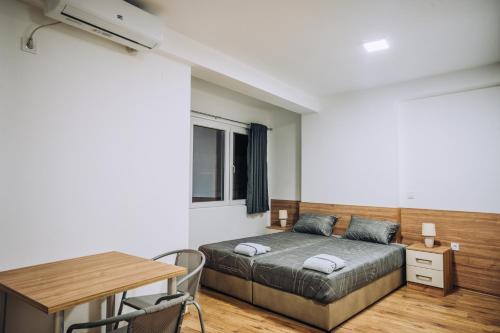 Schlafzimmer mit einem Bett, einem Schreibtisch und einem Tisch in der Unterkunft SANA Apartments in Ohrid
