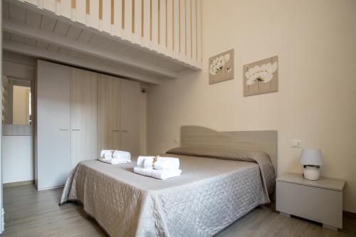 1 dormitorio con 1 cama con toallas en Case Vacanza Le Maioliche en Marsala
