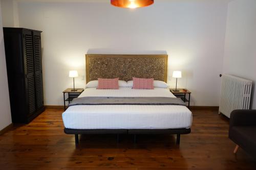 a bedroom with a large bed with two pink pillows at Fonda Biayna in Bellver de Cerdanya