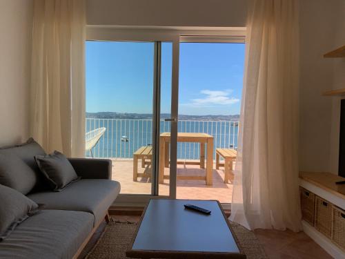 a living room with a couch and a view of the ocean at Oktheway Perbes Beach in Boebre