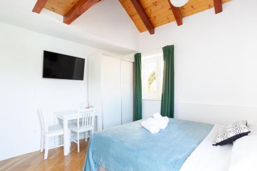 1 dormitorio con cama, mesa y TV en Orsan Residence, en Dubrovnik