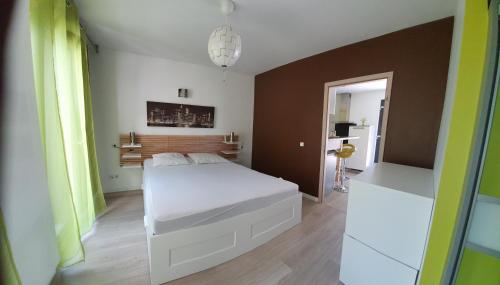 a bedroom with a white bed and a brown wall at Les Alizés in Holtzwihr