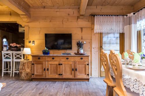 a living room with a television on a wooden wall at Chaty Zakopane in Zakopane