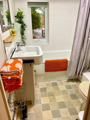 a bathroom with a sink and a bath tub at Holly Tree Cottage - 3 bedrooms and large garden with optional glamping double outside in Lymington