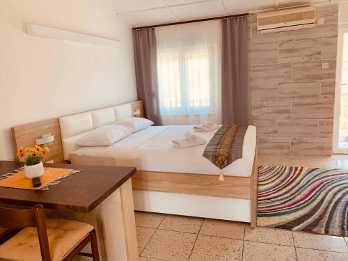 Schlafzimmer mit einem Bett, einem Tisch und einem Schreibtisch in der Unterkunft Apartments Knežević in Ulcinj