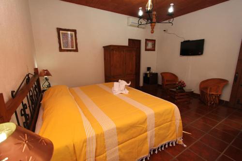 1 dormitorio con 1 cama con manta amarilla en Parador Monte Carmelo, en Oaxaca City