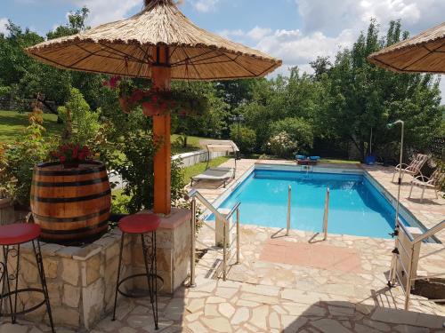 Mala Moštanica的住宿－VILA PEKEČ，一个带遮阳伞和桌椅的游泳池