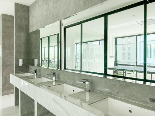 a bathroom with three sinks and large windows at ReLife Windy Naiharn by Beringela in Nai Harn Beach