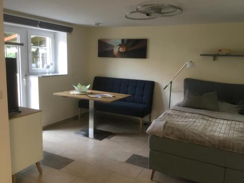ein Schlafzimmer mit einem Bett, einem Tisch und einem Sofa in der Unterkunft Ferienwohnungen An der Bimmelbahn Wernigerode in Wernigerode
