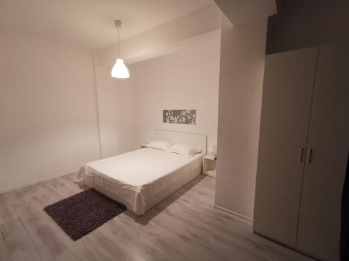 コンスタンツァにあるApartamente Sara 2013の白いベッドルーム(白いベッド1台、ラグ付)