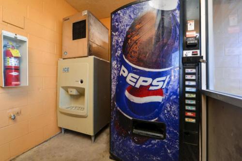 a pepsi vending machine next to a soda machine at Executive Inn in Fort Wayne