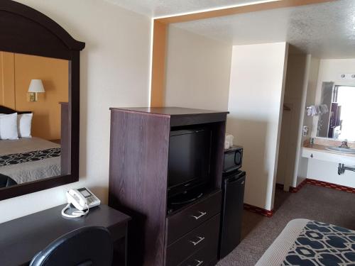 a hotel room with a bed and a flat screen tv at Split Mountain Motel in Vernal