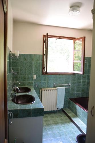 a green bathroom with three sinks and a window at 'Les Comètes' B&B in La Caujonnet