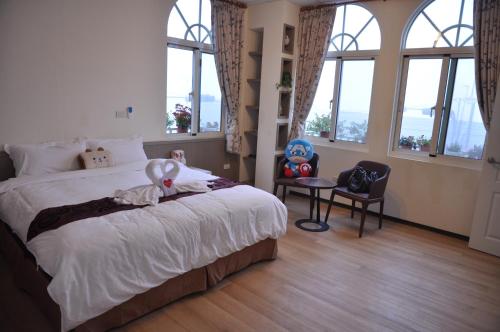 a bedroom with a bed and a chair and windows at David's House in Fanlu