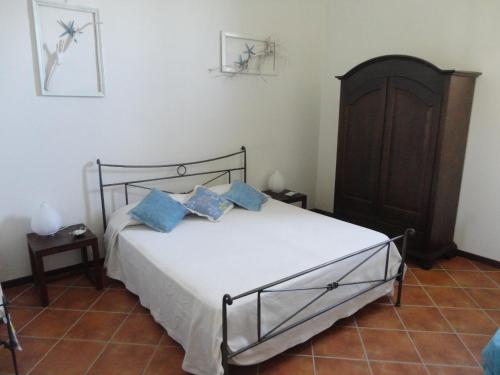 a bedroom with a bed with blue pillows on it at Da Marusca in Santa Marina Salina