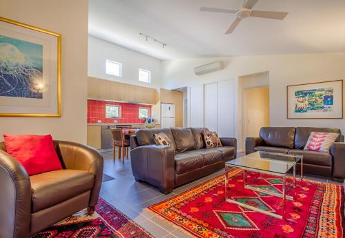 a living room with leather furniture and a table at Villa 28 Cape Villas in Dunsborough