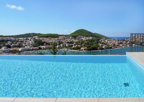 
a large swimming pool with a blue sky at Hotel Adria in Dubrovnik
