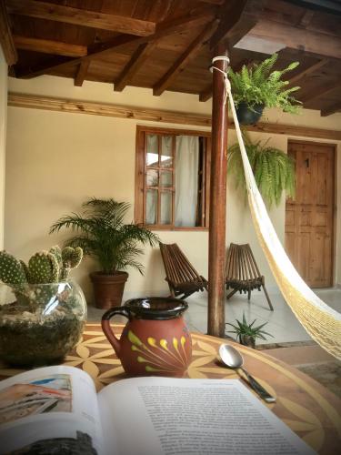 an open book on a table with a pot and a vase at Hotel Casa Azabache in San Cristóbal de Las Casas