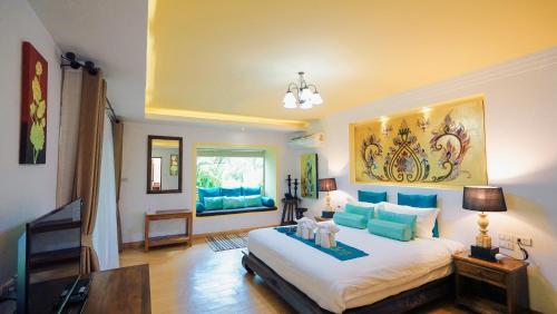 a bedroom with a large white bed with blue pillows at E-outfitting Boutique Chiang Mai in Chiang Mai
