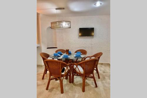 a dining room table with chairs and a television at Tu DEPA en el Paraíso Cancún 2 in Cancún