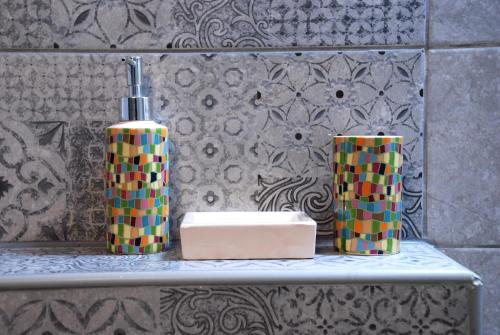 a shelf with two vases and a soap dispenser at Sevastie's Home - downstairs in Samothráki