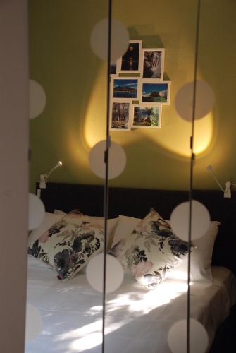 a bedroom with a bed with white sheets and pictures on the wall at Sevastie's Home - downstairs in Samothráki