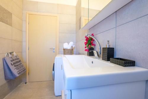 a bathroom with a white sink and a mirror at Rikia Seaside House in Rikia